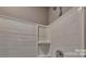 Close-up of a shower with white tiled walls and built-in shelving, showcasing clean lines and design at 3060 Ora Smith Rd, Lincolnton, NC 28092