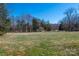 Expansive backyard featuring green space with mature trees in the background at 4151 Ivystone Ct, Charlotte, NC 28277