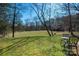 Spacious grassy backyard, wooded perimeter with view of a table and chairs set at 4151 Ivystone Ct, Charlotte, NC 28277