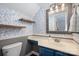 Stylish bathroom with gray wallpaper, floating shelves, and a blue vanity at 4151 Ivystone Ct, Charlotte, NC 28277