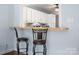Kitchen with an eat-at bar featuring two stools and white cabinets at 4151 Ivystone Ct, Charlotte, NC 28277