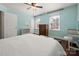 Bright bedroom with two windows, light blue walls, hardwood floors and a ceiling fan with light at 4151 Ivystone Ct, Charlotte, NC 28277