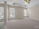 Spacious main bedroom features a ceiling fan, tray ceiling, and large windows for ample natural light at 604 Atherton Way, Rock Hill, SC 29730