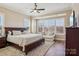 Bright main bedroom with large windows, a ceiling fan, and a cozy sitting area at 6301 Raven Rock Dr, Denver, NC 28037