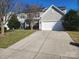 Charming two-story home featuring a two-car garage, well-manicured lawn and traditional architectural design at 7135 Tabor Falls Dr, Harrisburg, NC 28075