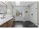 Bathroom featuring white subway tile, a window, a shower, and a wooden vanity at 7201 Brassy Creek Ln, Charlotte, NC 28269