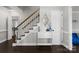 Bright entryway featuring a staircase with wood handrail, white accents, and hardwood flooring at 7201 Brassy Creek Ln, Charlotte, NC 28269
