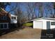 Backyard view featuring a brick home, garage and private driveway nestled among mature trees at 802 Lewis St, Gastonia, NC 28054