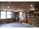 Unfinished basement with exposed wood ceiling, paint storage, and natural light at 802 Lewis St, Gastonia, NC 28054