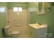 Well-lit bathroom with a toilet, tub-shower combo, and vanity with ample counter space at 802 Lewis St, Gastonia, NC 28054