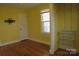Sunny yellow bedroom features hardwood floors, closet shelving, and a window at 802 Lewis St, Gastonia, NC 28054