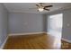 Spacious living room with hardwood floors, ceiling fan, and open doorway to another room at 802 Lewis St, Gastonia, NC 28054