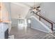 Bright living room with light gray walls, fireplace, ceiling fans, and staircase at 8552 Indian Summer Trl, Harrisburg, NC 28075