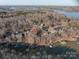 Aerial view of a lake house with private boat docks surrounded by lush trees and neighborhood homes at 8749 Dog Leg Rd # 7, Sherrills Ford, NC 28673