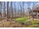 Lush backyard with mature trees, green grass, and a deck offers a private outdoor oasis at 8802 Glenside St, Huntersville, NC 28078