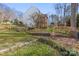 Landscaped backyard with a retaining wall and a tree sapling, perfect for outdoor enjoyment at 8802 Glenside St, Huntersville, NC 28078