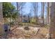 Backyard features a cozy fire pit area, surrounded by mature trees and a wooden fence at 8802 Glenside St, Huntersville, NC 28078