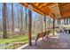 Covered patio with brick flooring and a bench overlooks a landscaped backyard with mature trees at 8802 Glenside St, Huntersville, NC 28078