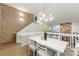 Open dining room with modern light fixture, wood wall, and view to living room at 8932 St Croix Ln, Charlotte, NC 28277