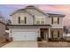 Charming two-story home showcasing a brick and siding facade, complemented by a two-car garage and manicured landscaping at 920 Clementine Rd, Monroe, NC 28110