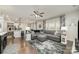 Open living room showcasing hardwood floors, a spacious gray sectional sofa, a large window, and seamless kitchen access at 920 Clementine Rd, Monroe, NC 28110