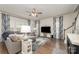 Inviting living room featuring hardwood floors, a plush gray sectional sofa, and bright windows with decorative curtains at 920 Clementine Rd, Monroe, NC 28110
