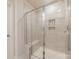 Tiled shower with glass door, built-in shelves, and a convenient bench for relaxation at 920 Clementine Rd, Monroe, NC 28110