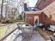 Back deck with wooden flooring, a brick home exterior, and an outdoor dining area with comfortable seating at 11309 Brittany Oaks Dr, Charlotte, NC 28277