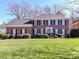 Classic brick home with manicured lawn, black shutters, and a welcoming entrance at 11309 Brittany Oaks Dr, Charlotte, NC 28277