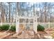 Landscaped backyard featuring a white pergola, mature trees, and manicured greenery for peaceful enjoyment at 1209 Waypoint Ct, Matthews, NC 28104