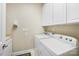 Practical laundry room with white cabinets, sink, and modern washer and dryer units at 1209 Waypoint Ct, Matthews, NC 28104