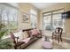 Well-lit sunroom with charming furniture and large windows perfect for relaxation and enjoying the natural light at 1209 Waypoint Ct, Matthews, NC 28104
