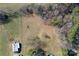 An aerial view of a property with open land, storage buildings, and wooded boundaries at 1433 Buffalo Shoals Rd, Catawba, NC 28609