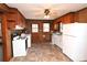 Cozy kitchen featuring white appliances, vintage wood paneling, and updated vinyl flooring at 1433 Buffalo Shoals Rd, Catawba, NC 28609