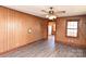 Spacious living room with vintage wood paneling, ceiling fan, and new vinyl flooring at 1433 Buffalo Shoals Rd, Catawba, NC 28609