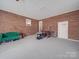 Unfinished basement with exposed brick and carpeted floors offers lots of potential at 1525 Oakridge Dr, Salisbury, NC 28146