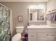Bright bathroom featuring a vanity with storage, framed mirror, shower-tub and vibrant tropical curtain at 1525 Oakridge Dr, Salisbury, NC 28146