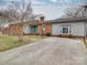 Single-story brick home featuring a concrete driveway and a quaint front yard at 1525 Oakridge Dr, Salisbury, NC 28146