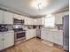 Well-lit kitchen featuring stainless steel appliances, wood-look floors and bright white cabinets at 1525 Oakridge Dr, Salisbury, NC 28146