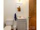 A functional half bathroom with a toilet, sink, and small gray vanity at 1590 Daybreak Ridge Rd, Kannapolis, NC 28081