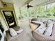 Inviting covered back porch featuring wicker furniture, a ceiling fan and views of the surrounding greenery at 1590 Daybreak Ridge Rd, Kannapolis, NC 28081