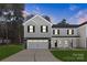 New two-story townhouse with gray and white siding, black shutters, and a spacious two-car garage at 1608 Breezewood Dr, Charlotte, NC 28262