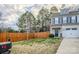 Inviting front yard with a wood fence and partial view of the two-story townhome at 203 Makayla Ct, Fort Mill, SC 29715