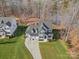 Stunning aerial view of a home showcasing its well-manicured lawn, three car garage, and proximity to a serene lake at 2127 Nims Village Dr, Fort Mill, SC 29715