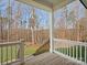 Relaxing back porch with white railing overlooking the scenic backyard and lush greenery at 2127 Nims Village Dr, Fort Mill, SC 29715