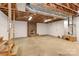 Large unfinished basement featuring open ceiling and brick fireplace at 2274 Old Wilkesboro Rd, Statesville, NC 28625