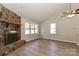 Cozy living room features wood floors, a stone fireplace, and natural light streaming through windows at 2274 Old Wilkesboro Rd, Statesville, NC 28625