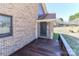 The deck is made of stained wood and is attached to the brick exterior with a storm door leading inside at 2274 Old Wilkesboro Rd, Statesville, NC 28625