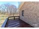 A view of the dark stained wooden deck attached to the brick exterior with a railing around the perimeter at 2274 Old Wilkesboro Rd, Statesville, NC 28625
