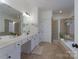 Primary bathroom featuring a double sink vanity, soaking tub, and walk-in shower at 228 Black Mountain Dr, Fort Mill, SC 29708